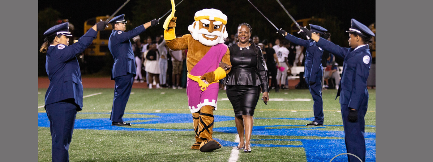 Principal Sims with mascot during homecoming game